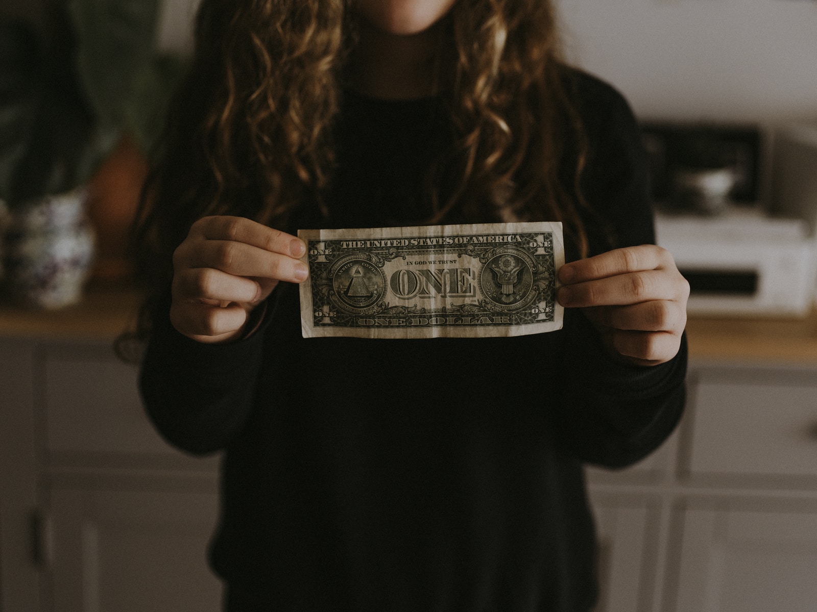 girl holding 1 U.S. dollar banknote